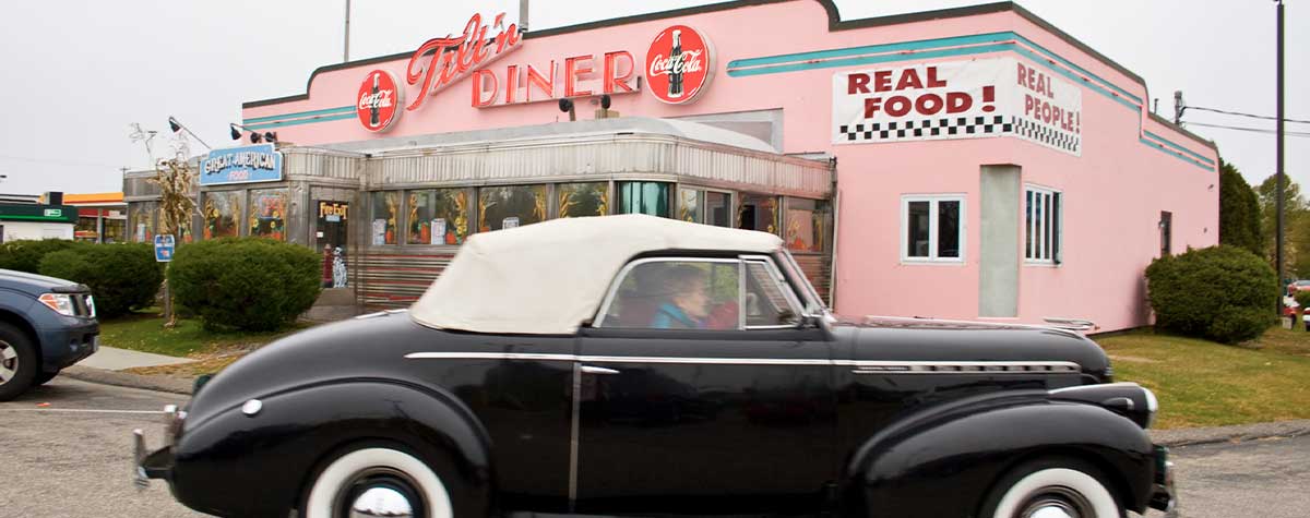 black classic car in front of tilt'n diner