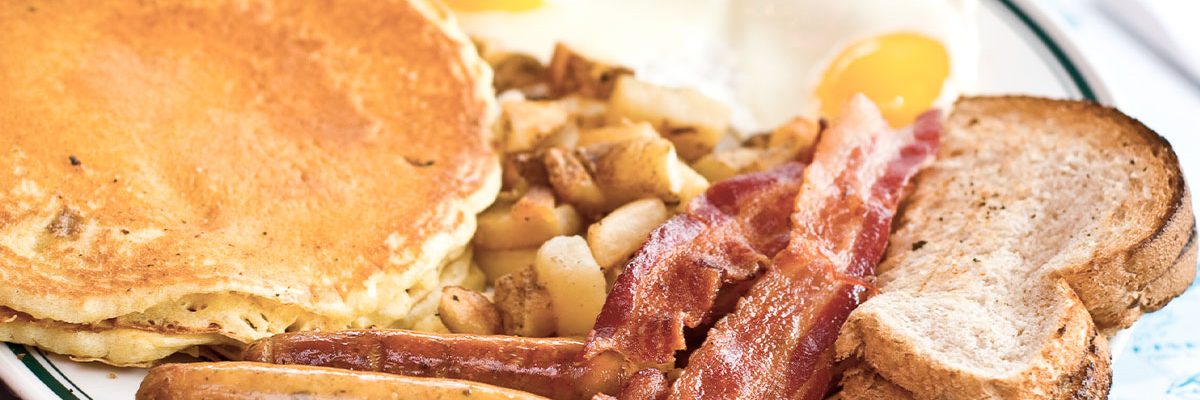 pancakes, sausage, bacon, toast and sunnyside up eggs breakfast platter