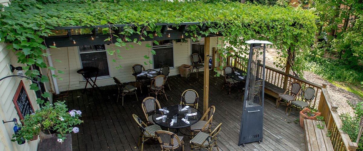 italian farmhouse arbor covering tables on outside patio