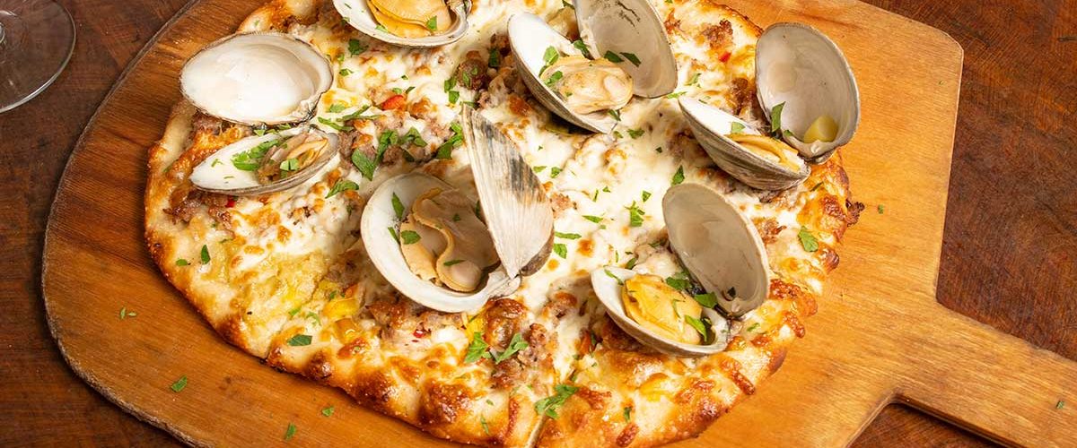 clam pizza on wooden board