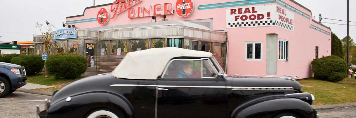 black classic car in front of tilt'n diner